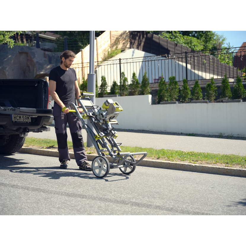 Person transportiert eine Kappsäge auf einem Untergestell.