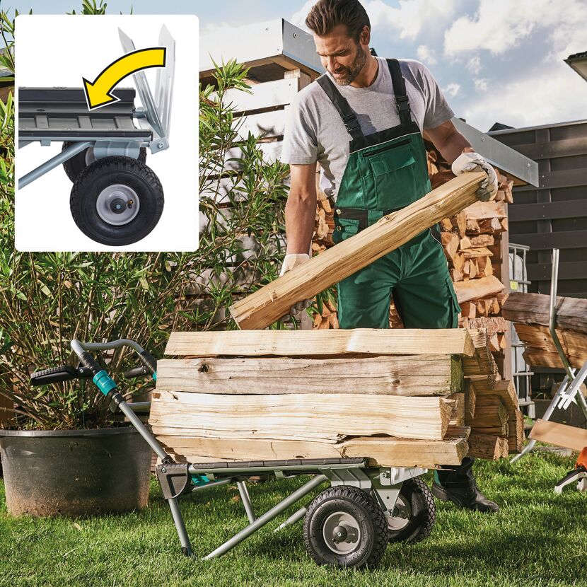 Person transportiert Holzscheite mit Transportkarre.