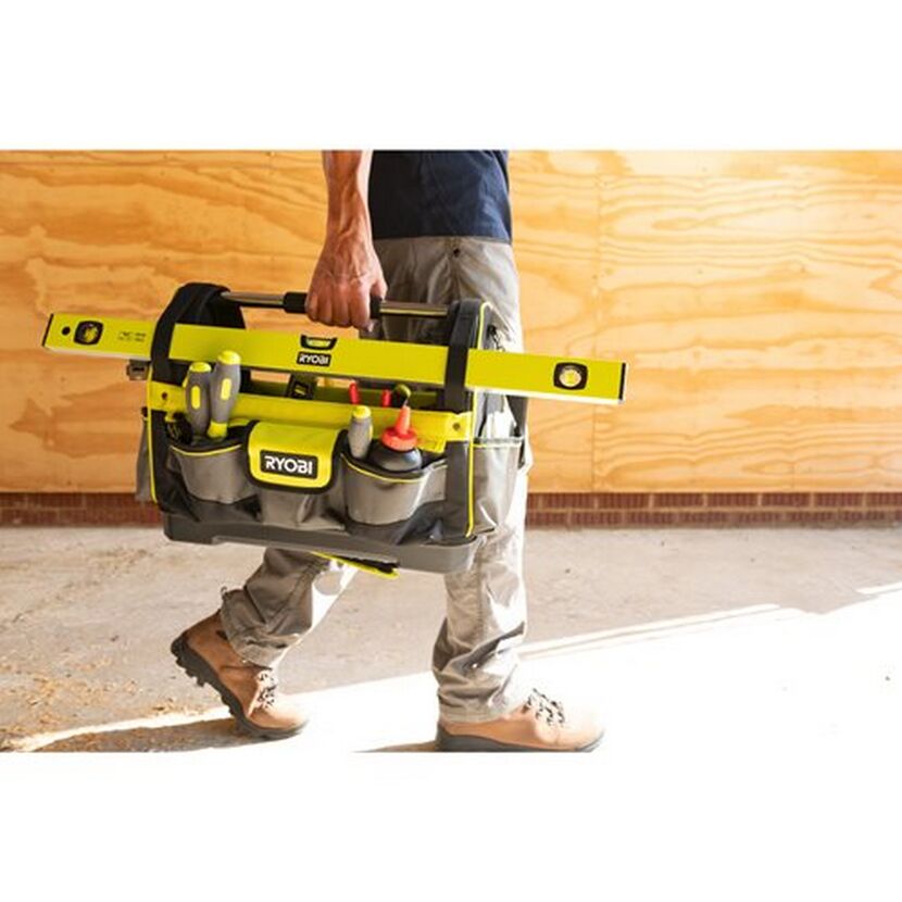 Person trägt eine Ryobi Werkzeugtasche mit Wasserwaage und Werkzeug.