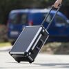 Person zieht schwarzen Werkzeugkoffer