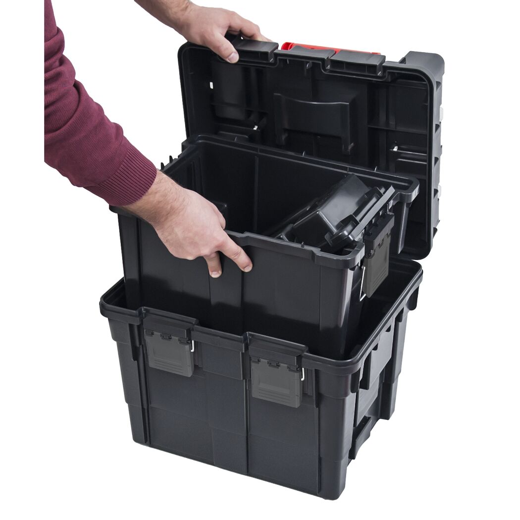 Person packt Werkzeug Rollbox