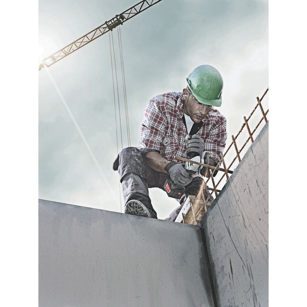 Person verwendet einen Winkelschleifer auf einer Baustelle.