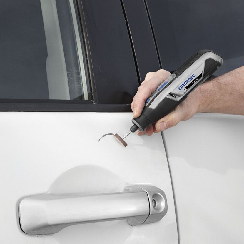 Person verwendet Dremel Lite zum Abschleifen eines Autos.