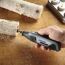 Person bearbeitet Birkenholz mit dem Dremel Lite.