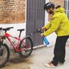 Person reinigt Fahrrad mit Hochdruckreiniger