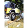 Person reinigt einen gelben Jeep mit einem Hochdruckreiniger.