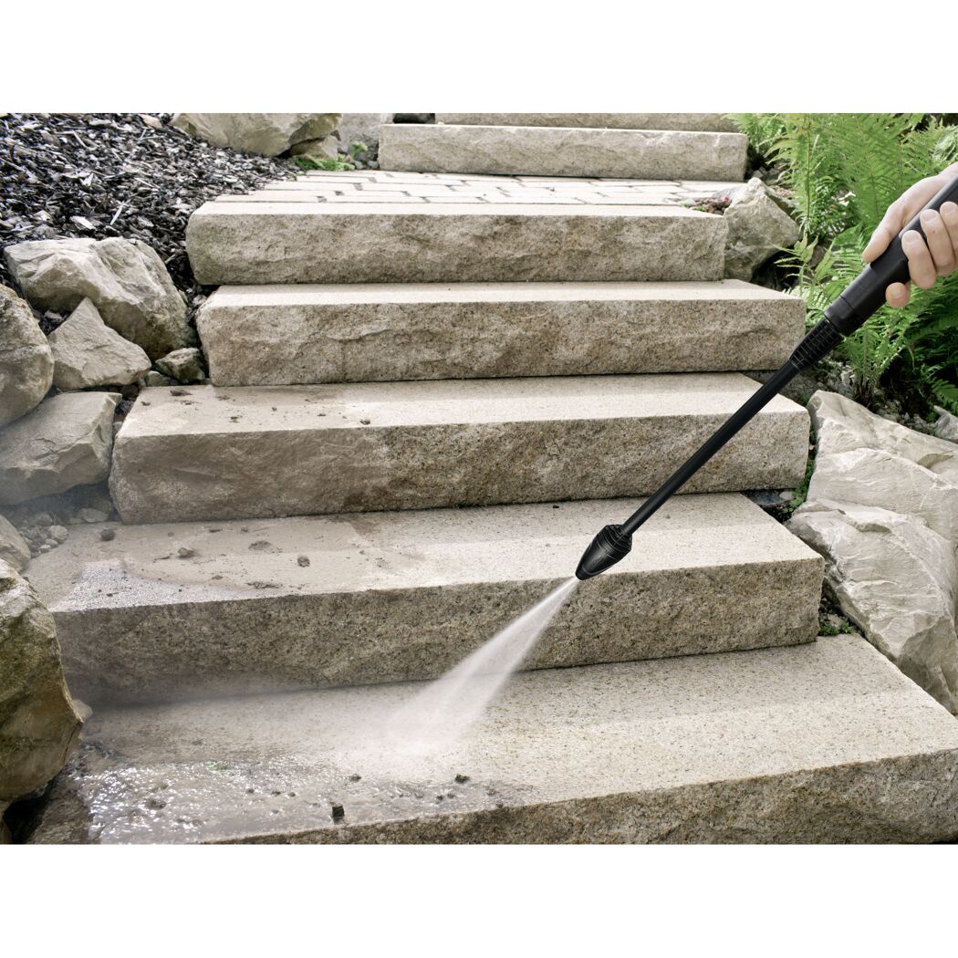 Person reinigt Steintreppe mit Hochdruckreiniger