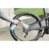 Person reinigt Fahrrad mit Sprühflasche