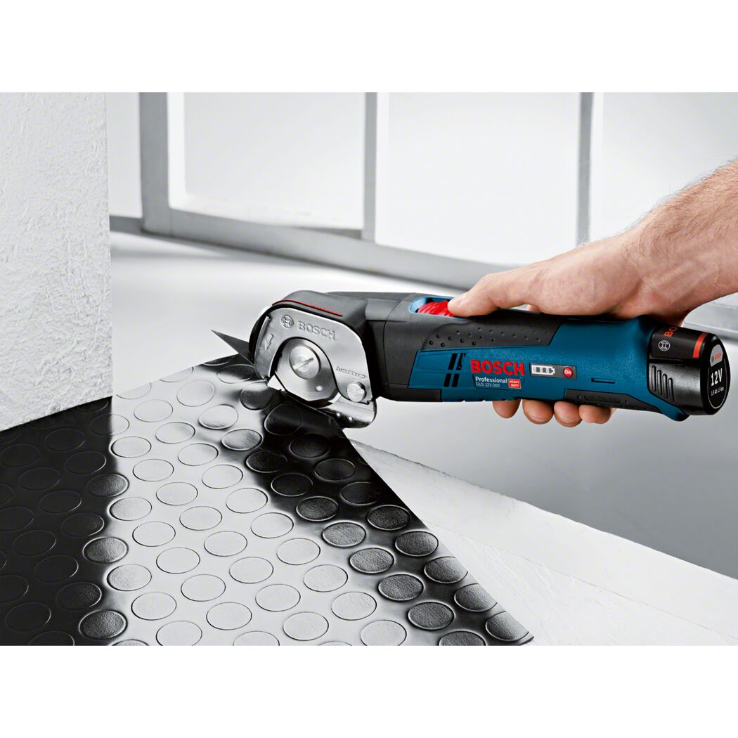 Person schneidet mit Akku-Multi-Cutter Gummimatte zu.