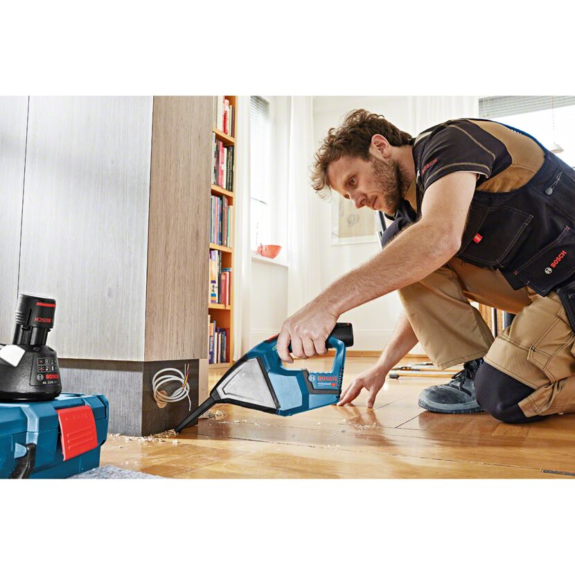 Person saugt mit einem Bosch Akku-Sauger Staub auf.