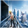 Person beim Anschrauben einer Glasscheibe mit Akkuschrauber an Hochhausfassade
