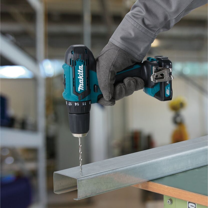 Person bohrt mit einem Makita Akku-Bohrschrauber in ein Metallprofil.