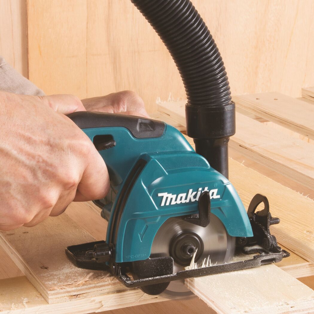 Person sägt mit einer Makita Handkreissäge ein Stück Holz.