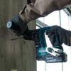 Person bohrt mit einem Akku-Bohrhammer in eine Betonwand.
