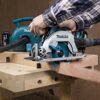 Person sägt Holz mit einer Makita Akku-Handkreissäge.