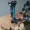 Person sägt mit einem Makita Multifunktionswerkzeug in ein Stück Holz.