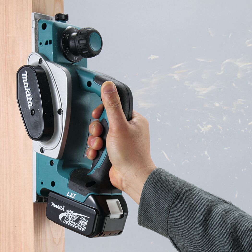 Person verwendet einen Makita Akku-Hobel an einem Holzstück.
