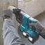 Person bohrt mit Akku-Kombihammer in Betonwand.