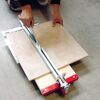 Person schneidet Fliese mit Fliesenschneider