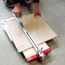 Person schneidet Fliese mit Fliesenschneider