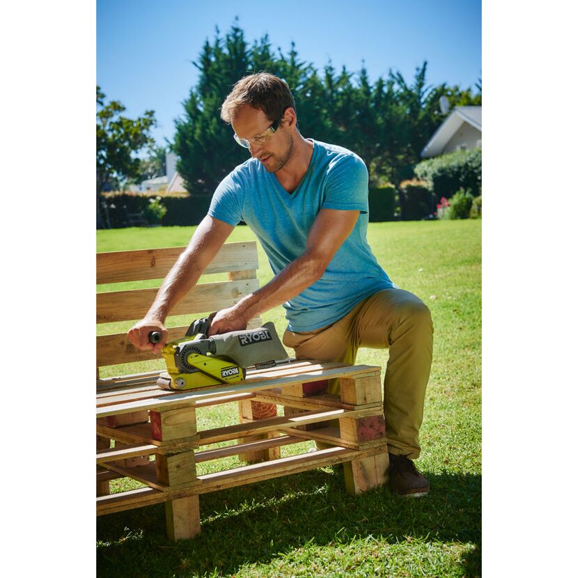 Person schleift Holz mit RYOBI Bandschleifer