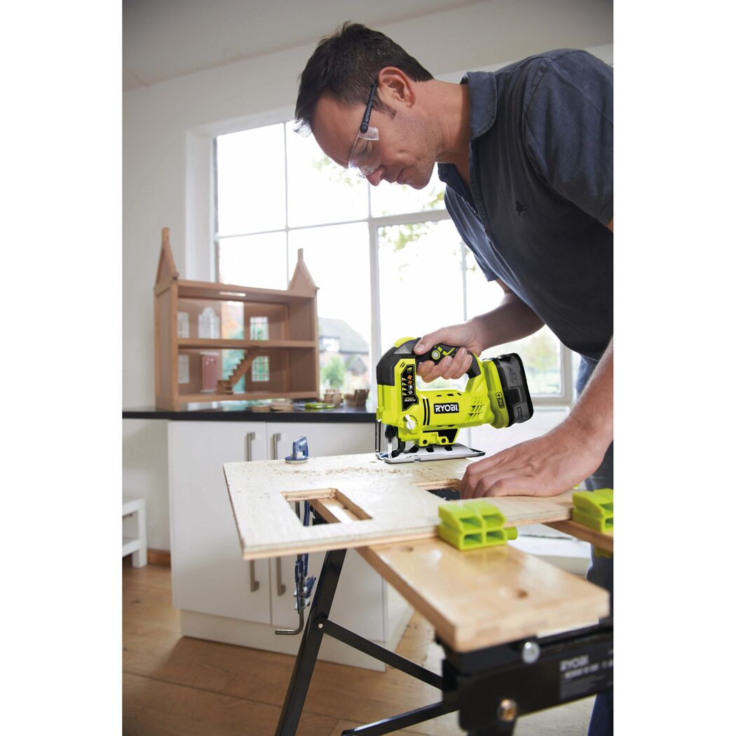 Person sägt mit einer Ryobi Stichsäge ein Stück Holz.