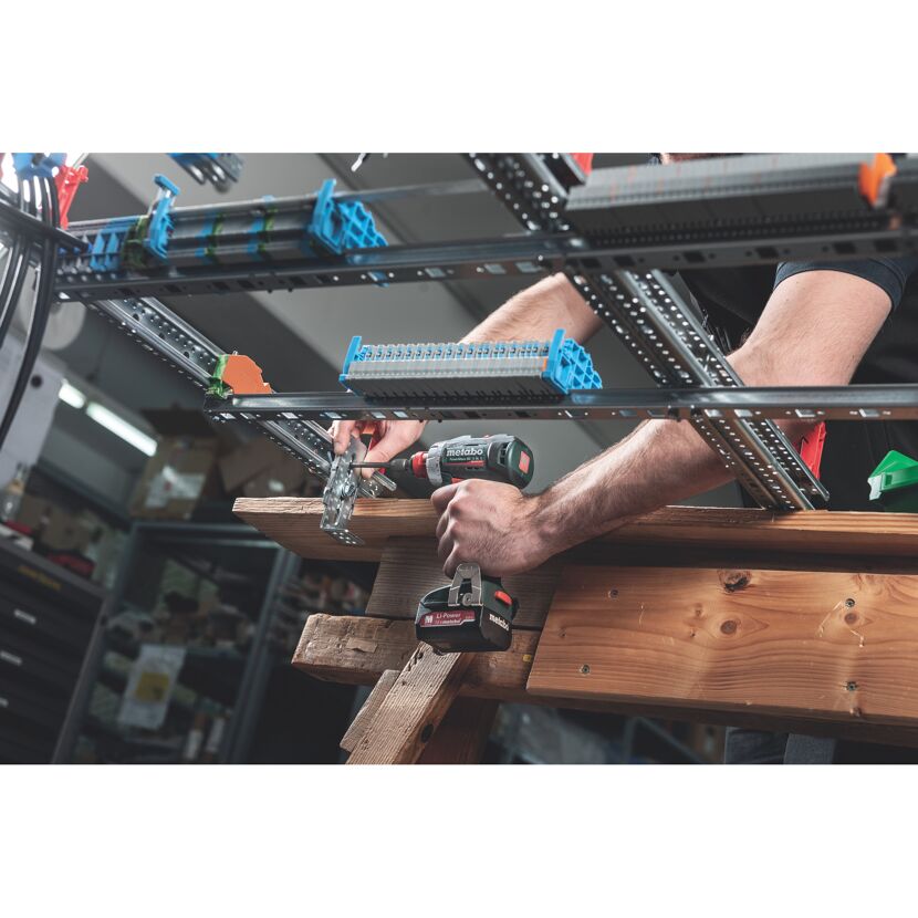 Person montiert mit einem Akku-Bohrschrauber von Metabo eine Metallkonstruktion.