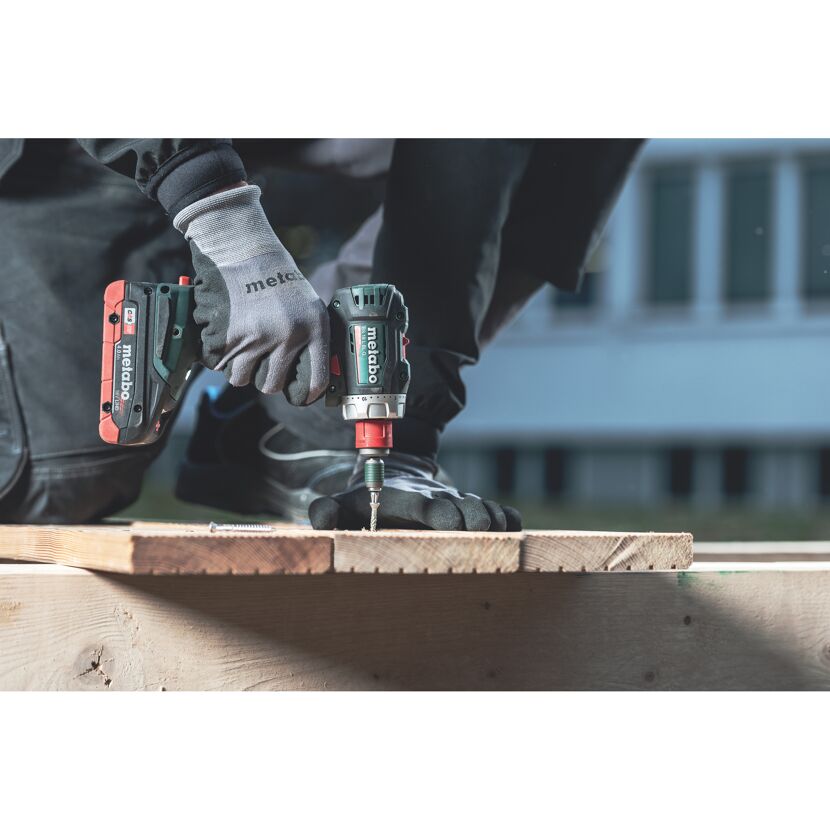 Person verschraubt Holz mit einem Akku-Bohrschrauber von Metabo.