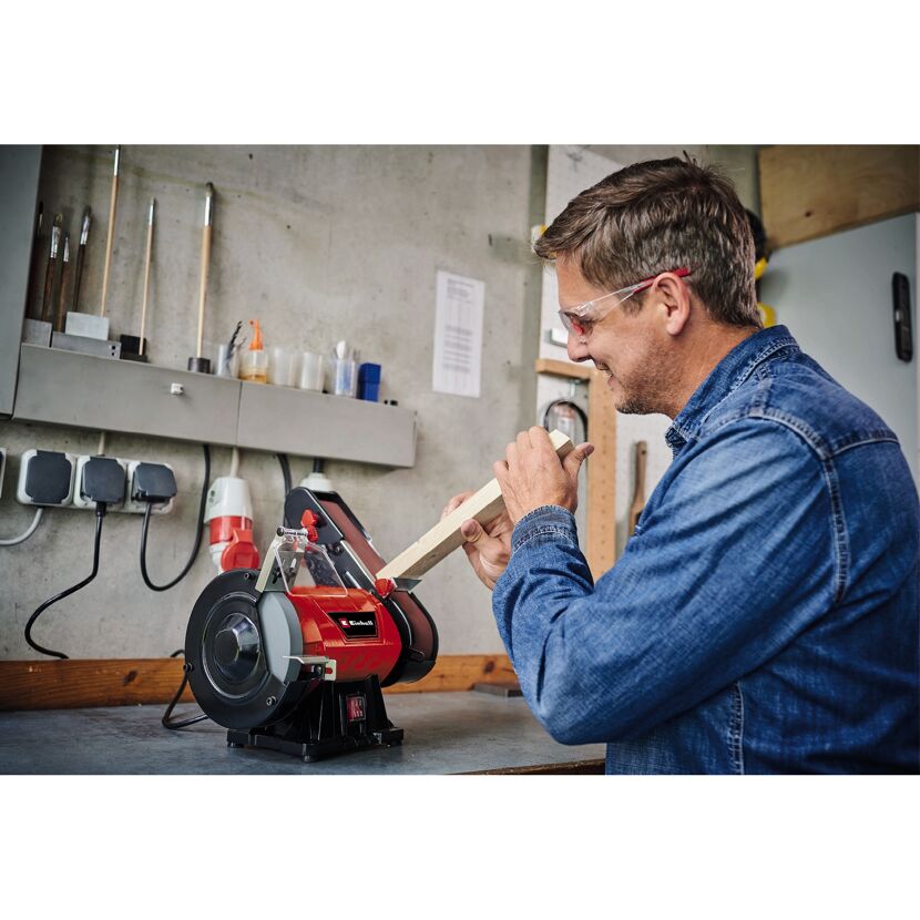 Person schleift Holz mit einem Einhell Stand-Bandschleifer