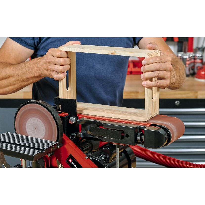Person schleift Holz mit Bandschleifer