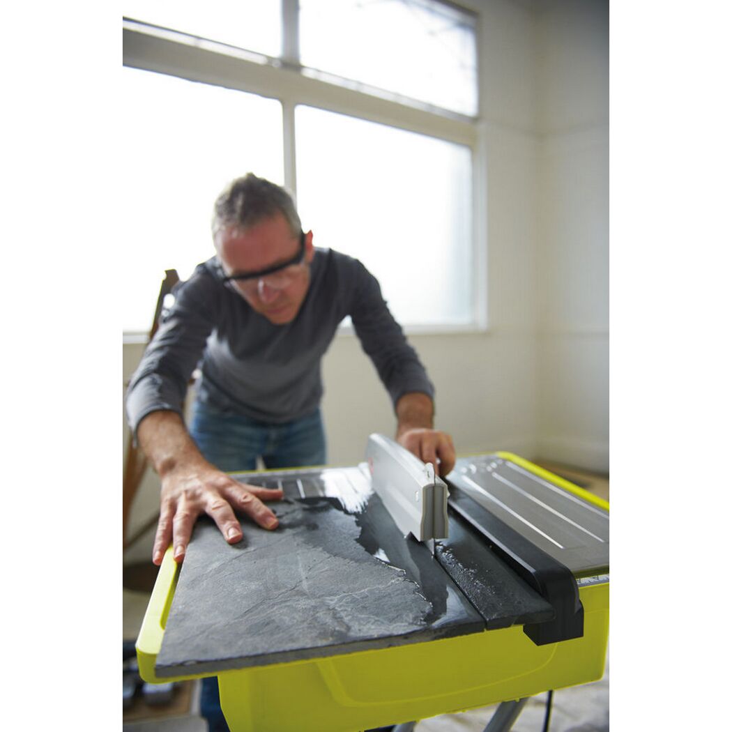 Person schneidet Fliese mit Fliesenschneider