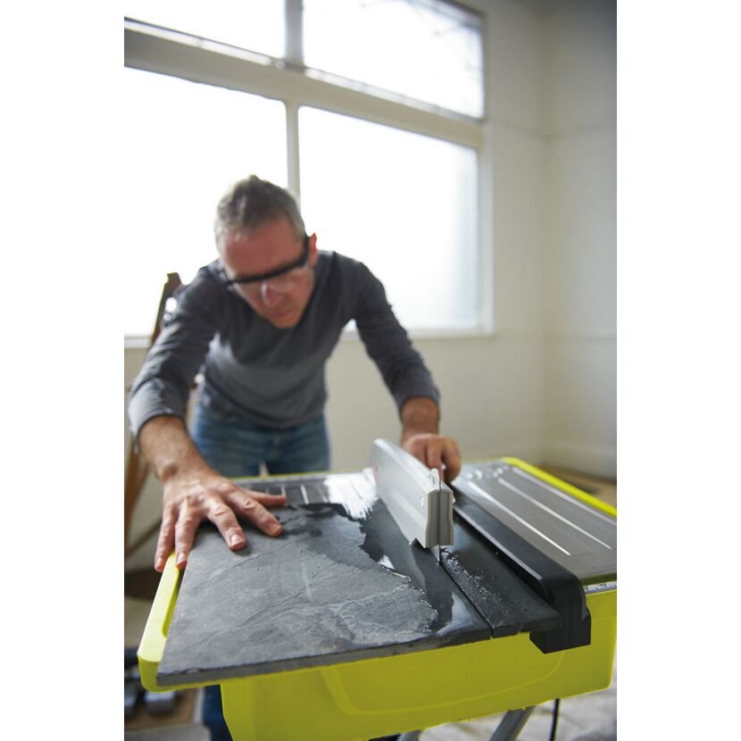 Person schneidet Fliese mit Fliesenschneider