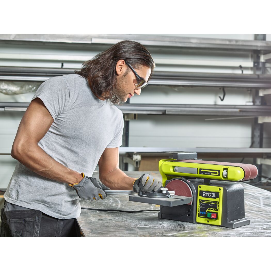 Person schleift Metallstück mit Bandschleifer