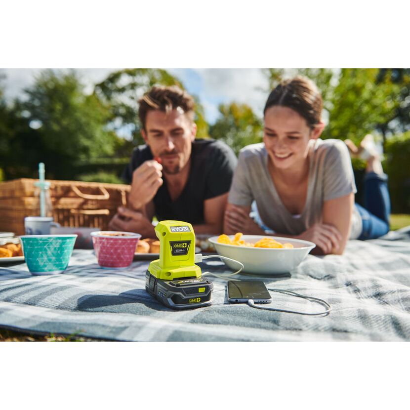 RYOBI Akku-USB-Adapter lädt Smartphone beim Picknick.