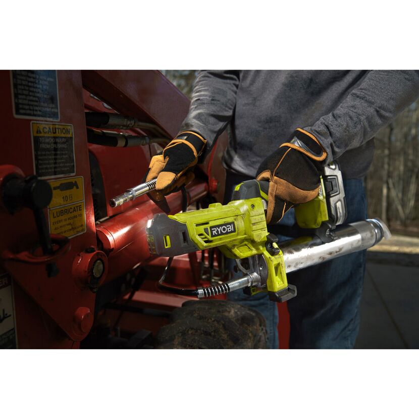 Person fettet mit RYOBI Akku-Fettpresse ein rotes Gerät ein.