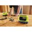 Person bearbeitet mit einem RYOBI Werkzeug ein Werkstück auf dem Tisch. Im Vordergrund die RYOBI Akku Bluetooth Box.