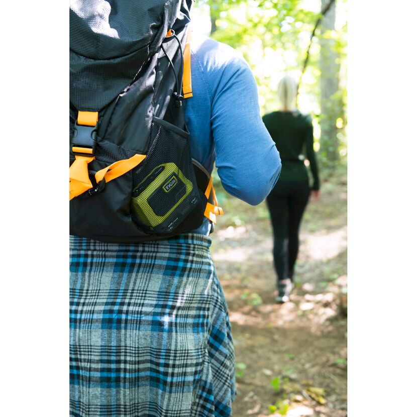 Person mit Rucksack und tragbarer Bluetooth-Box