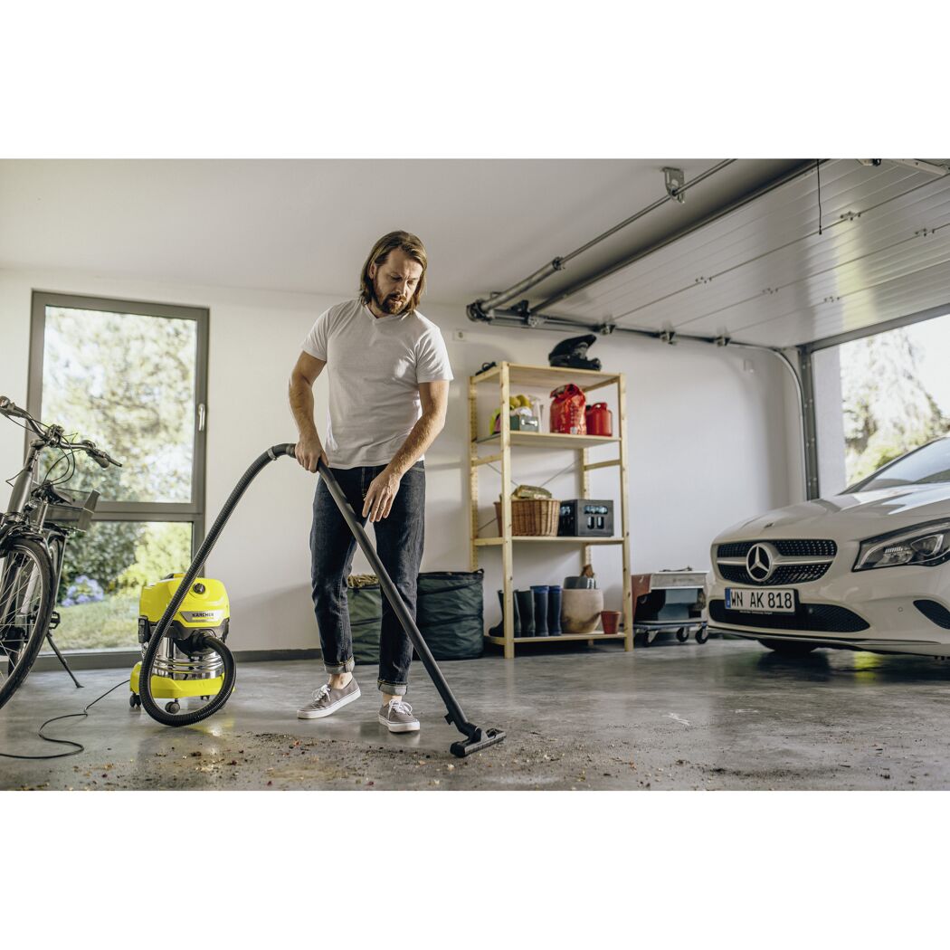 Person saugt Garage mit Kärcher Nass-Trockensauger.