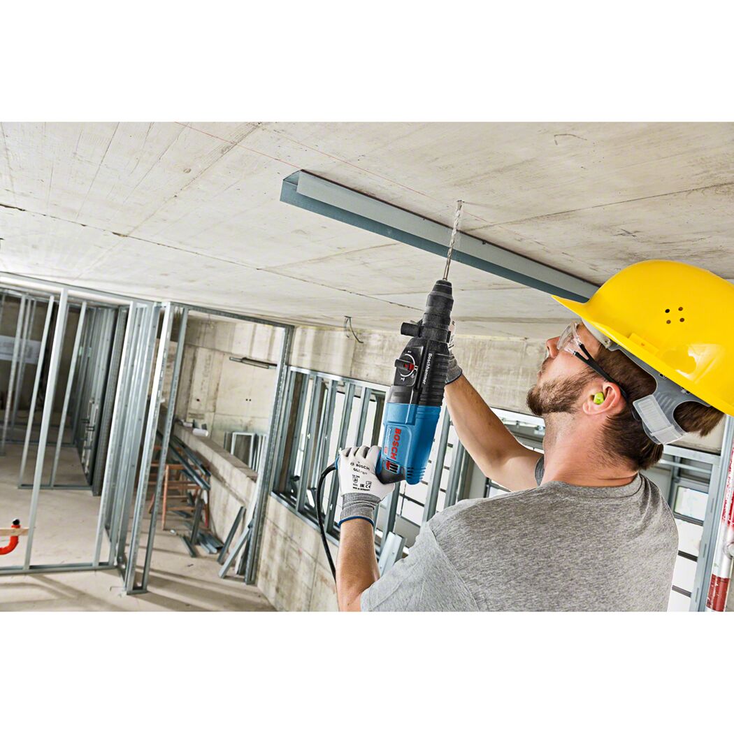 Person bohrt mit Bohrhammer in Decke