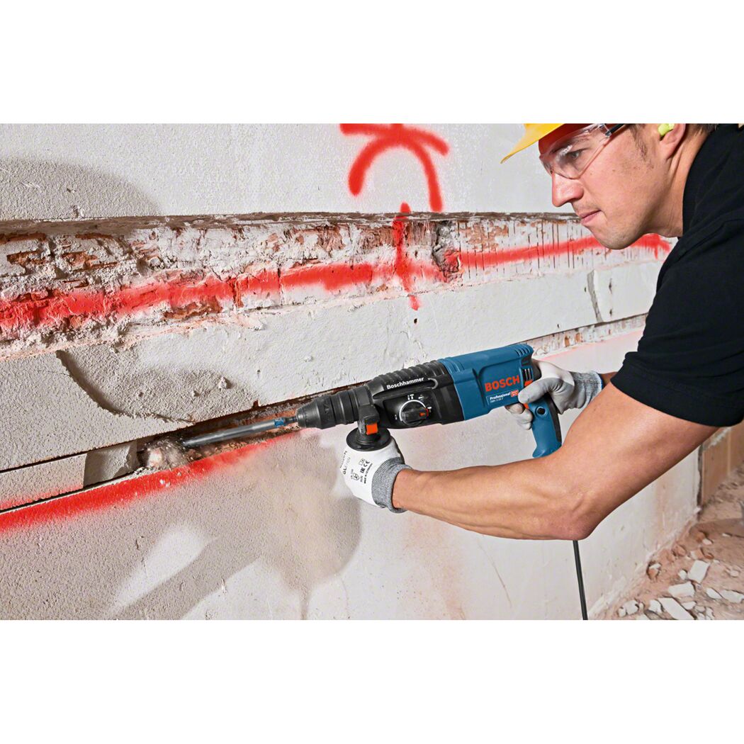 Person verwendet einen Bohrhammer der Marke Bosch an einer Wand.
