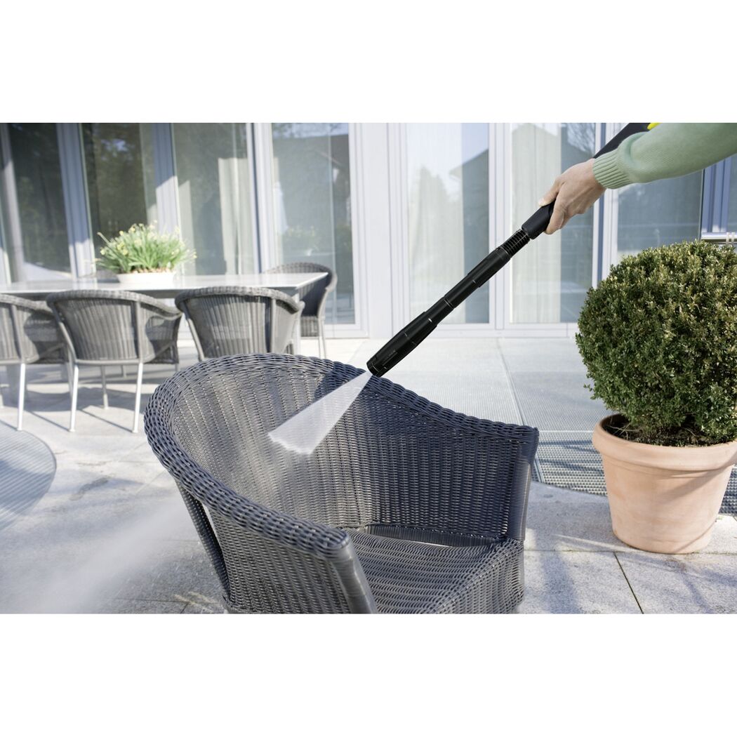 Person reinigt Gartenmöbel mit Hochdruckreiniger