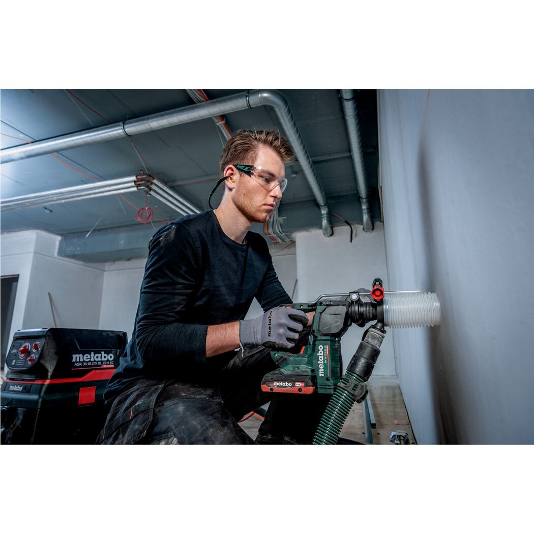 Person bohrt mit einem Metabo Akku-Bohrhammer in eine Wand.