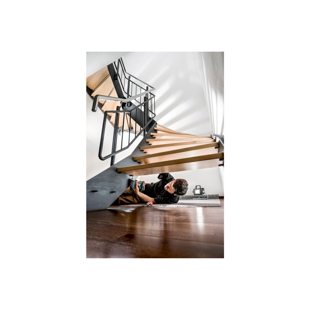 Person repariert mit einem Akkuschrauber eine Treppe.
