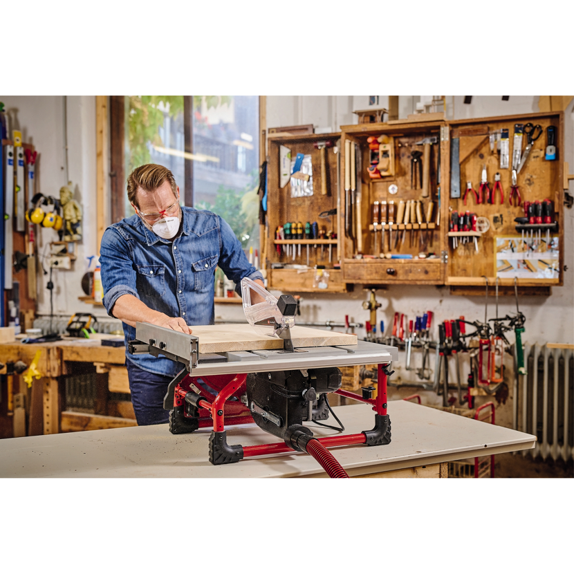 Person sägt Holz mit Tischkreissäge.