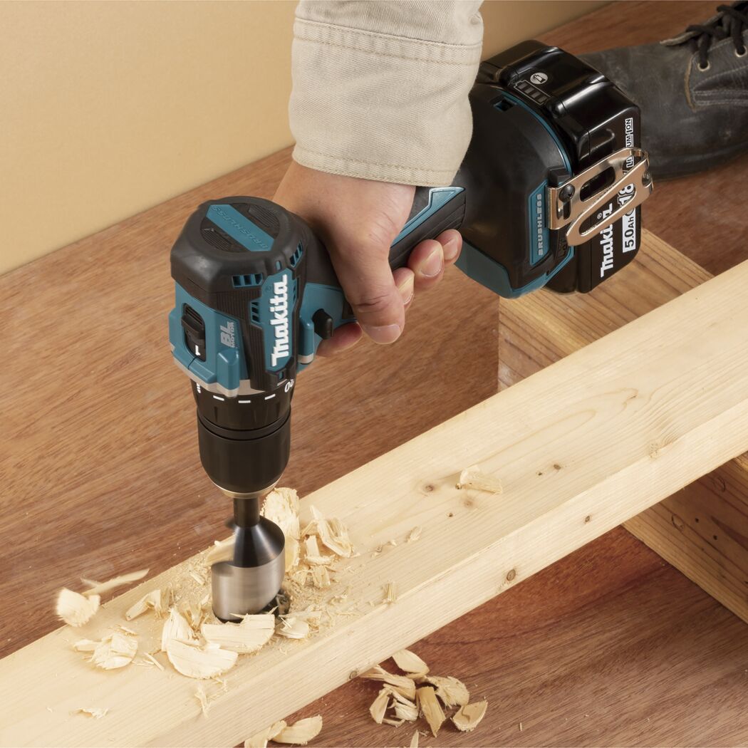 Person bohrt mit Makita Akku-Bohrschrauber in Holz.