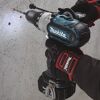Person bohrt mit Makita Akku-Schrauber in Wand