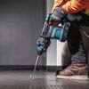 Person mit Makita Meißelhammer beim Meißeln von Fliesen