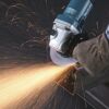 Person schleift Metall mit Winkelschleifer von Makita