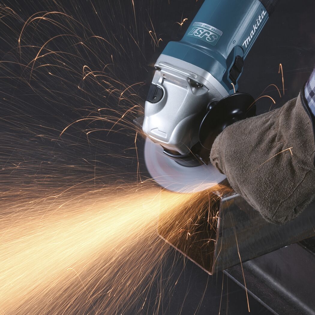 Person schleift Metall mit Winkelschleifer von Makita