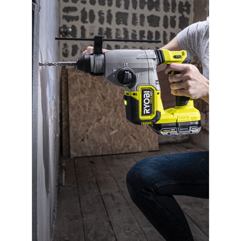 Person bohrt mit dem Akku-Bohrhammer SDS RSDS18X-1C40S von Ryobi ein Loch in die Wand.